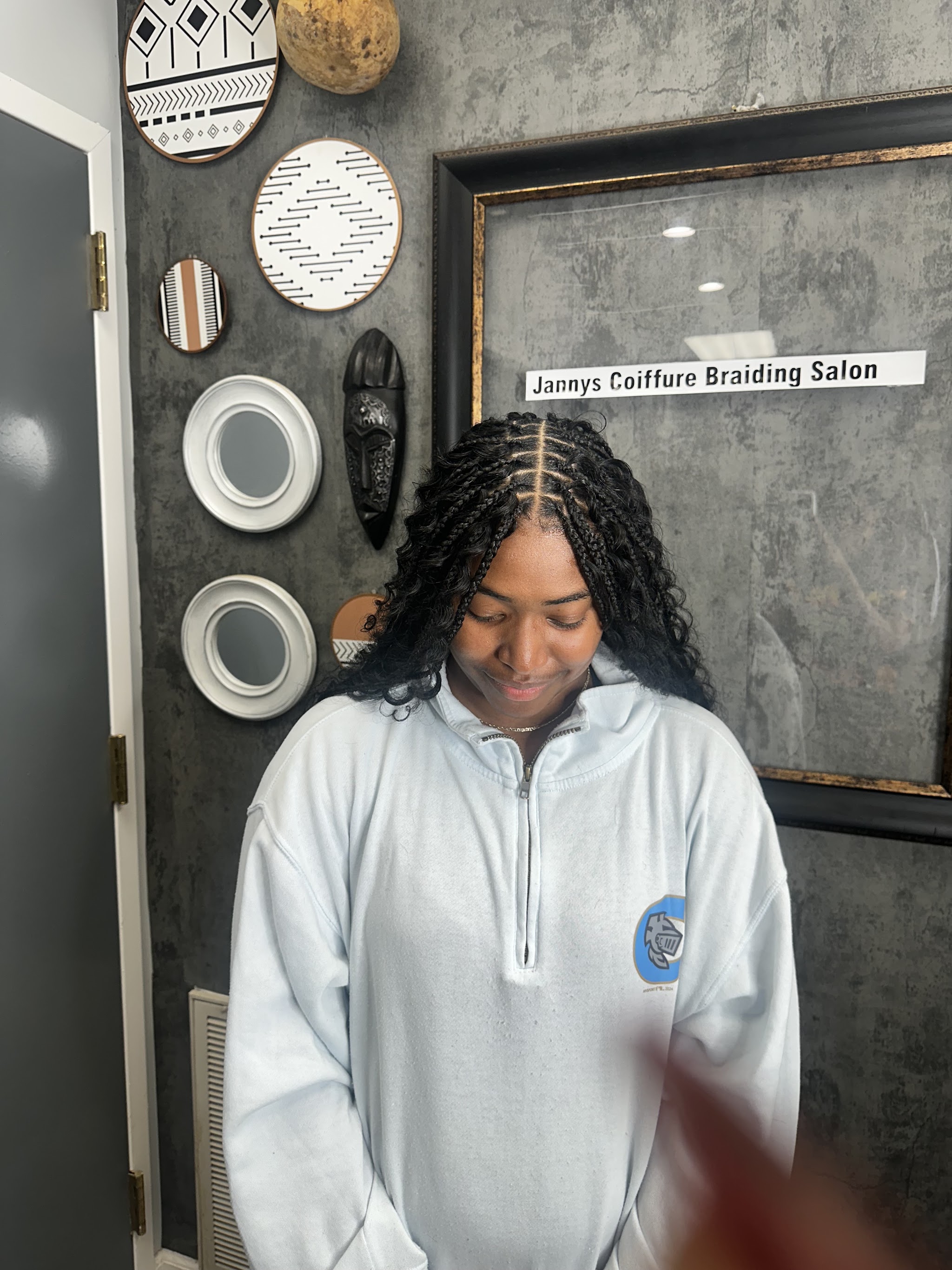 Middle-parted twists on a smiling client